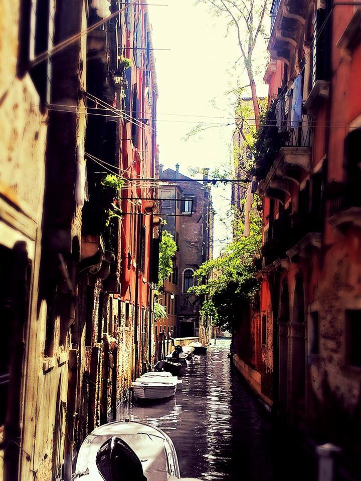 Boats along a canal in Venice Italy