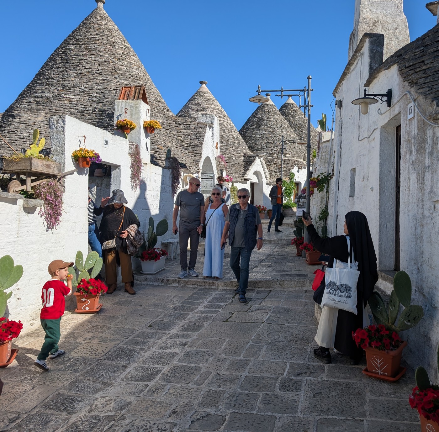 nun in alberobello standing in a typical street