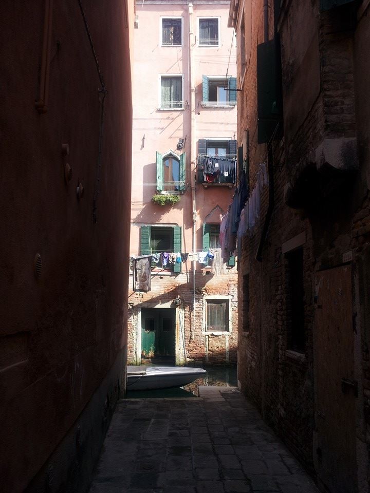 Washing hangs above a canal in Venice Italy
