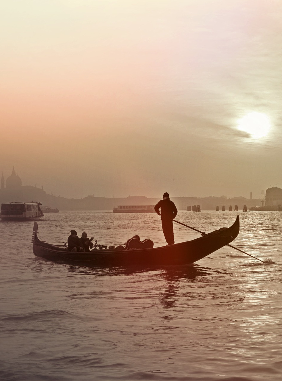 Winter in Venice, a lone gondola heads out with two passengers, well wrapped against the winter chill.